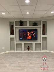 large white room with large screen tv mounted to wall with decorations surrounding it in Lawrenceville, GA