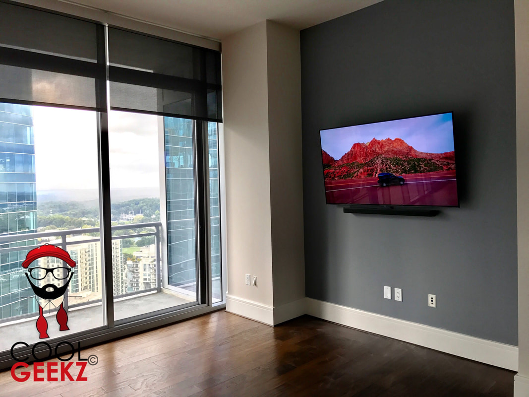mounted flat tv on grey wall by large windows in Lawrenceville, GA